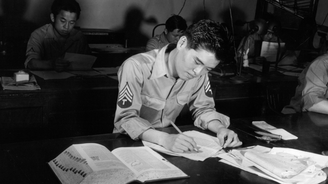 A Japanese-American soldier checks a document in Tokyo, Japan to determine its accuracy.